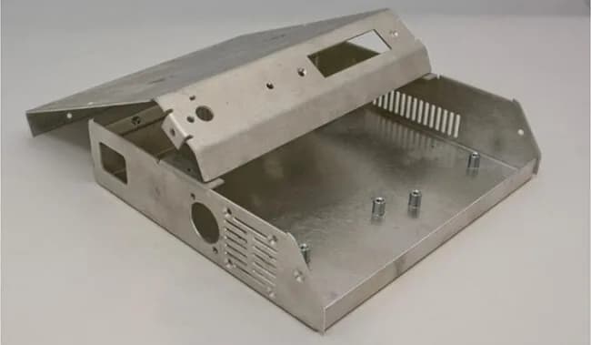 Sheet metal equipment housing with ventilation slots