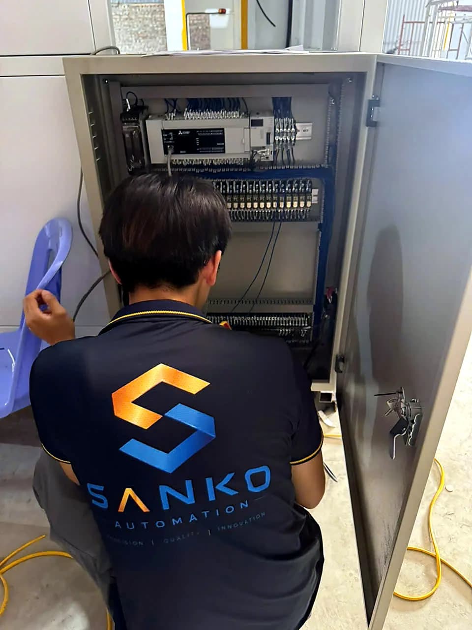 Kỹ thuật viên Sanko đấu nối dây trong tủ điện điều khiển có PLC