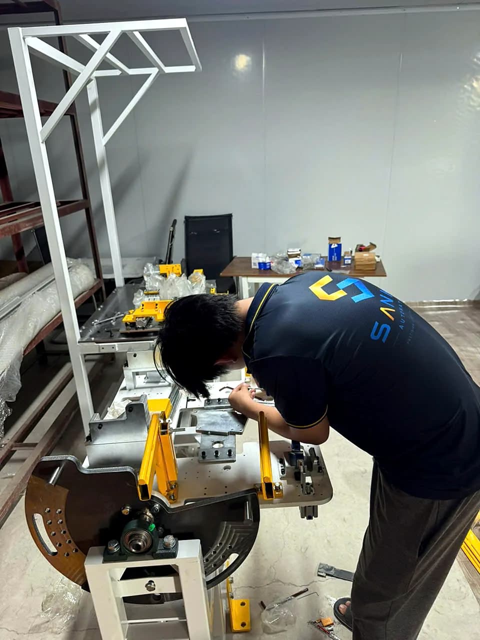 Kỹ thuật viên lắp đặt cụm thiết bị trên bàn máy